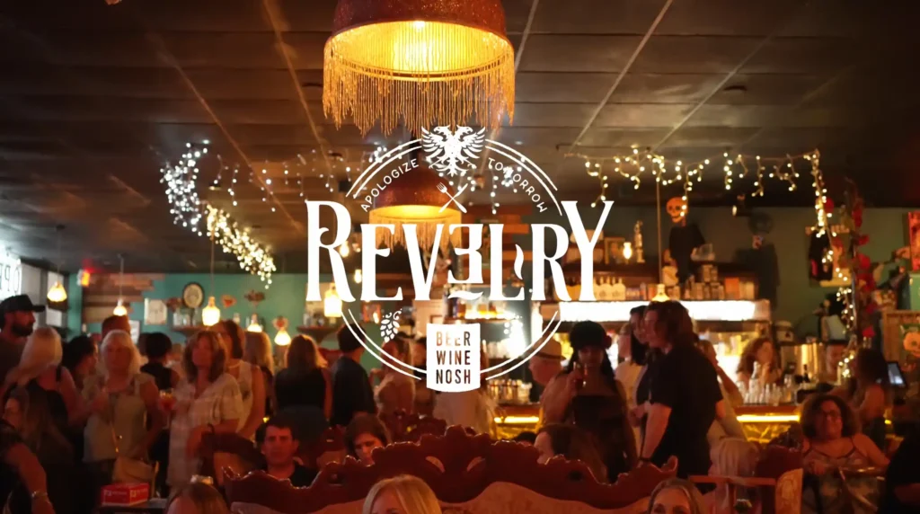 Revelry bar at night warm lights a full bar of guests near boat show